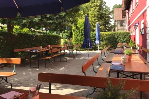 Stegners Landbiergarten mit Tischen unter idyllischem Ahornbäumen